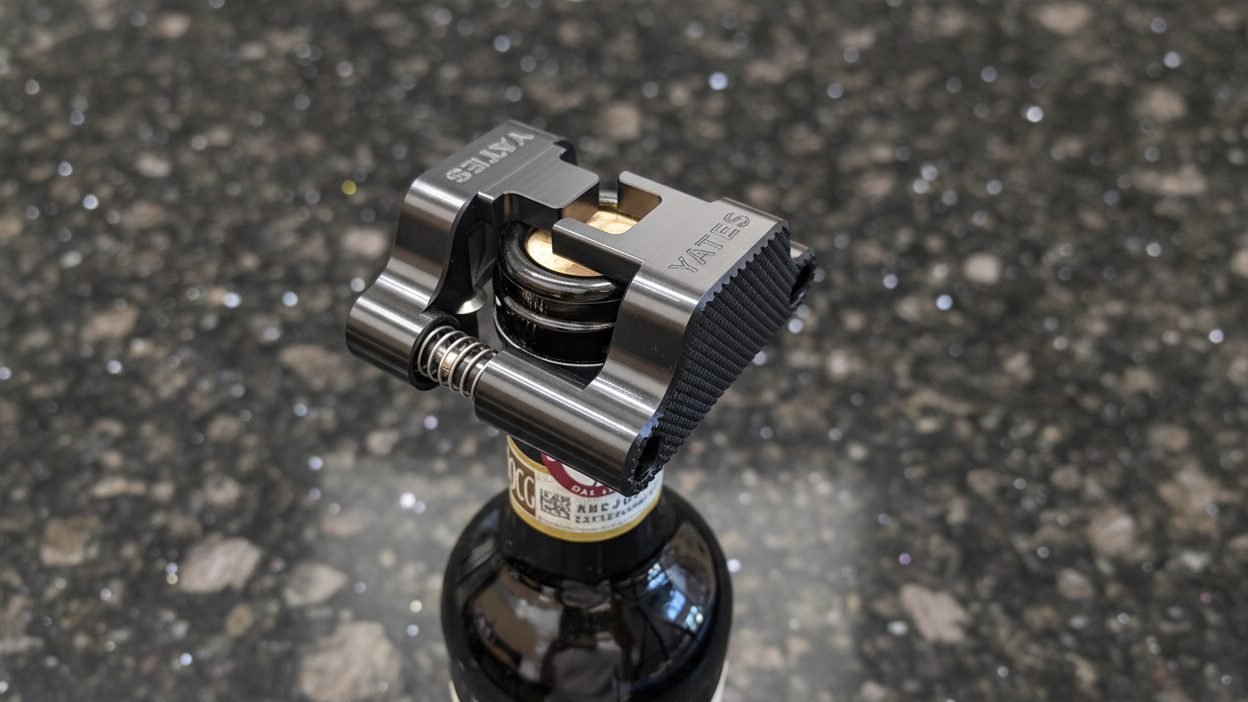 A 16:9 ratio "Hero" photo of the Yates wine foil cutter sitting on top of the wine bottle ready to cut the foil. There is no human hand holding it, instead it sits level by itself on top of the bottle. 