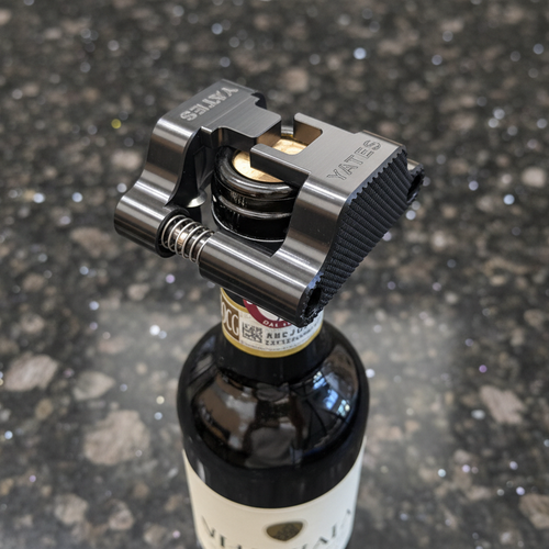 A photo of the Yates wine foil cutter sitting on top of the wine bottle ready to cut the foil. There is no human hand holding it, instead it sits level by itself.